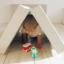 Load image into Gallery viewer, Child playing with toy cars inside a cardboard box fort on a wooden floor.
