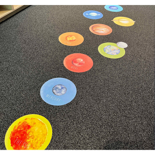 Colorful solar system floor stickers on a textured surface