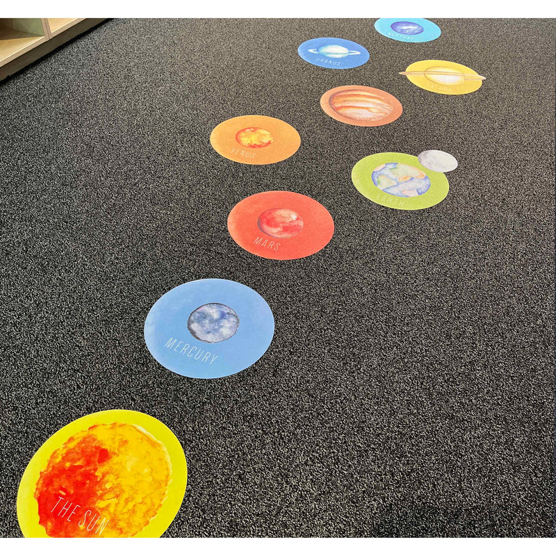 Colorful solar system floor stickers on a textured surface
