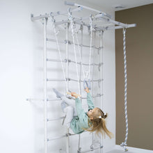 Load image into Gallery viewer, Child playing on a wall-mounted climbing structure with ropes and monkey bars.
