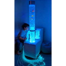 Load image into Gallery viewer, Child looking at a glowing cylindrical aquarium with fish inside, surrounded by blue light.
