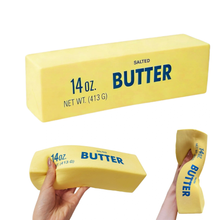 Load image into Gallery viewer, Three views of a novelty stretchy butter bar, including one hand holding it and one showing its elastic stretch, on a white background.
