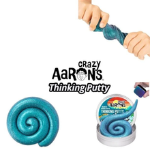 Load image into Gallery viewer, Crazy Aaron's Thinking Putty in a glittery teal-blue color, shown in a spiral shape, with hands stretching the putty at the top and a container of the product at the bottom right.
