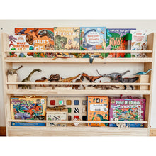 Load image into Gallery viewer, Wooden bookshelf with children&#39;s books and dinosaur toys on a white wall background
