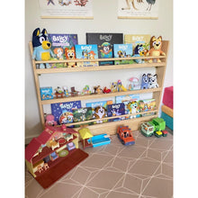 Load image into Gallery viewer, Children&#39;s toys and books on a wooden shelf with a toy barn and cars on the floor.
