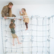 Load image into Gallery viewer, Children playing on a climbing frame indoors with a woman supervising.
