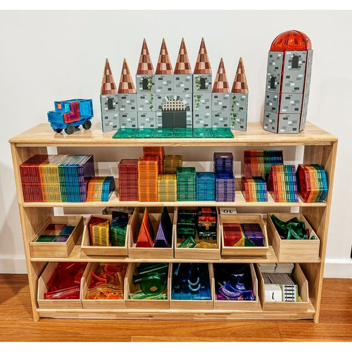 Wooden shelf with educational toys and building blocks on a wooden floor.