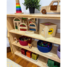 Load image into Gallery viewer, Wooden toys and educational items on a shelf with a plant in the background.
