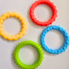 Load image into Gallery viewer, Four colorful silicone teething rings on a light background
