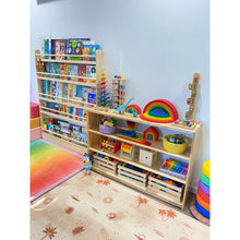 Load image into Gallery viewer, Children&#39;s playroom with wooden shelves filled with toys and books, colorful rug on the floor.
